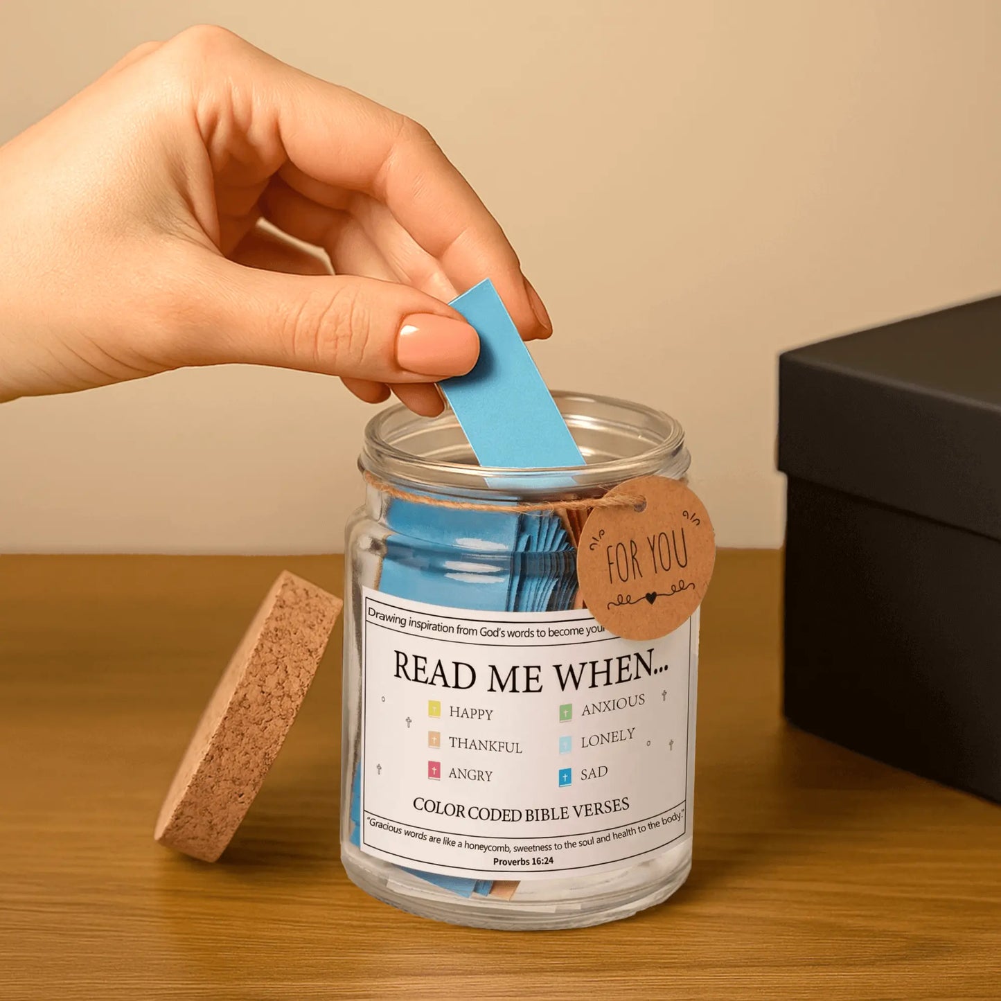 Hand pulling out a blue scroll from the Handmade Bible Verses Jar labeled for “sad” moments, highlighting the ease of use and personal encouragement found in this Scripture-filled Christian gift.
