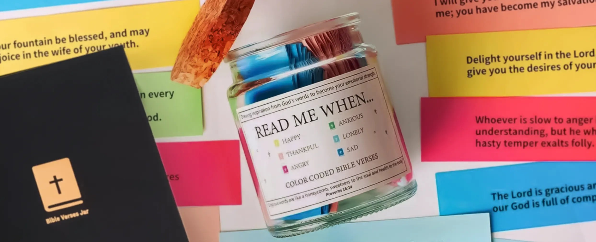 Open glass jar labeled “Read Me When…” from the brand Remina, filled with color-coded Bible verses for different emotions like happy, anxious, and thankful, surrounded by colorful scripture cards and a black Christian gift box with a cross icon.